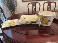 Stack of four large plates, one small plate and ice bucket on table