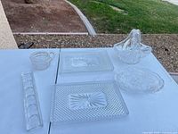 All six clear cut glass serving pieces on table