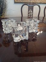 Three crystal tealight holders grouped on wood table