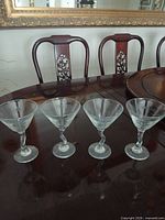 Four martini glasses on table showing overall condition and design