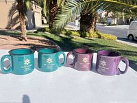 Group shot of four Salt Lake 2002 mugs, two teal, two purple