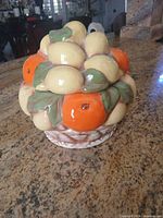 Full view of closed ceramic candy dish showing fruit cluster design