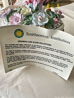 overall view of lidded porcelain box with Smithsonian information card for scale context