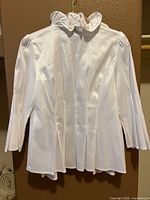 Back view of white sateen blouse showing sheen, long sleeves, pleat details