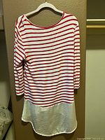 Front view of red and white striped pullover shirt on hanger