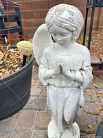 Front view of full angel statue showing praying pose and intact left wing