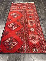 Full view of red handmade rug showing design and size
