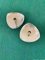 Top view of the two triangular stainless candle holders showing form and finish