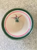 Top view of ceramic bowl showing Fireweed motif, pink inner ring and green rim