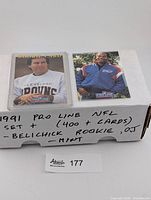 Closed storage box with two featured cards in top loaders, handwritten note on box detailing contents