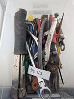 Bin showing assorted hand tools including staple gun, wrenches, snips, screwdrivers