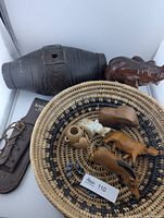 Group view of barrel, basket, knife sheath, large elephant and small figurines