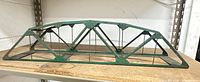 Full side view of green Lionel metal truss bridge