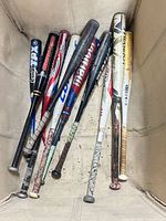 Top-down view of ten softball bats laid together showing brands, colours, condition
