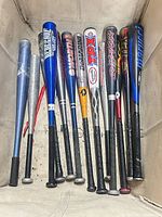 All 12 assorted baseball bats laid out side-by-side showing colours, brands and wear