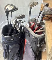 Two golf bags filled with assorted clubs
