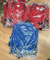 Stacks of red and blue shirts sealed in plastic