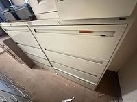 Two beige 4-drawer lateral file cabinets side by side showing drawers, recessed pulls and lock