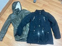 Black and olive jackets laid flat showing fronts, full view