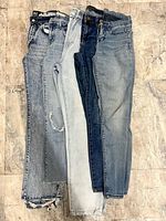 Five pairs women’s jeans size 25, assorted washes, displayed side by side