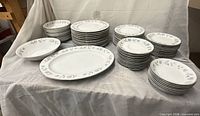 Full set of stacked plates, bowls and platter on tablecloth