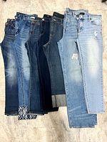 All seven pairs of size 14 women’s jeans displayed side-by-side showing range of washes and minor details