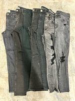 Five of the seven pairs of size 6 women’s jeans laid flat to show color and style variation