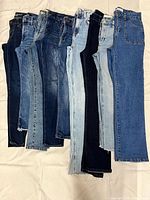 Nine pairs of women’s size 4 jeans in assorted washes laid flat