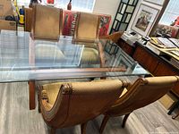 Full view of glass dining table and three of four chairs