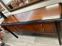 Angled view of entire sideboard showing top surface, front, legs, hardware