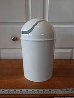 Front view of white Umbra mini waste can with swing lid