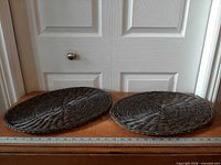 Both oval chocolate polyrattan placemats side-by-side