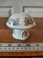 Front view of mushroom house money box beside ruler