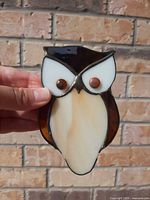 front view of stained glass owl held by hand