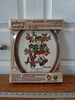 Front view of sealed Gallery Crafts Hummel Stitchery kit in package