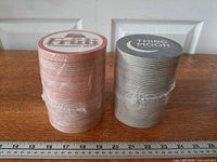 Two wrapped stacks of beer coasters side by side on table