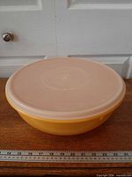 Side view of yellow Tupperware bowl with lid