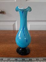 Full profile of blue vase showing shape and black base