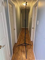 Stand fully extended in hallway, showing height and tripod legs