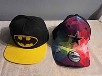 Front view of both caps showing logos, colours and visor styles