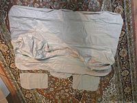 Deflated beige inflatable backseat lounger laid flat, showing overall shape with two support cushions and center pad