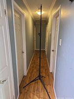 Full height view of black aluminum light stand in hallway