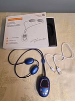 Retail box, neck massager, USB cable visible