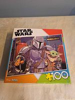 Front of puzzle box showing Mandalorian and Grogu, 100-piece count, Buffalo branding