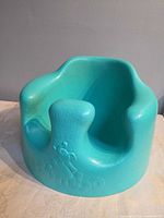 Front-angled view of teal Bumbo floor seat