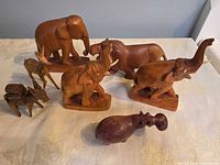 Front angled view showing all seven carved wood animal figurines