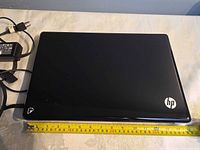 Top view of closed HP laptop showing lid and ruler for scale