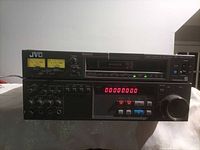 Front view of JVC BR-S622DXU showing controls, LED counter, jog/shuttle wheel