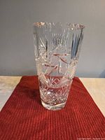 Full view of clear cut crystal vase on red cloth