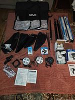 Entire kit laid out: bag, softboxes, stands, heads, bulbs, accessories